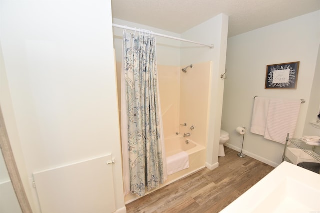 bathroom featuring toilet, shower / bath combination with curtain, and hardwood / wood-style flooring