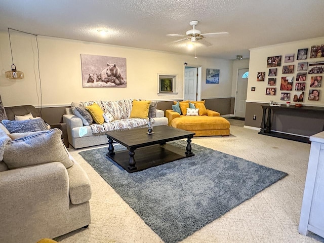 living room featuring ceiling fan, carpet, and a textured ceiling