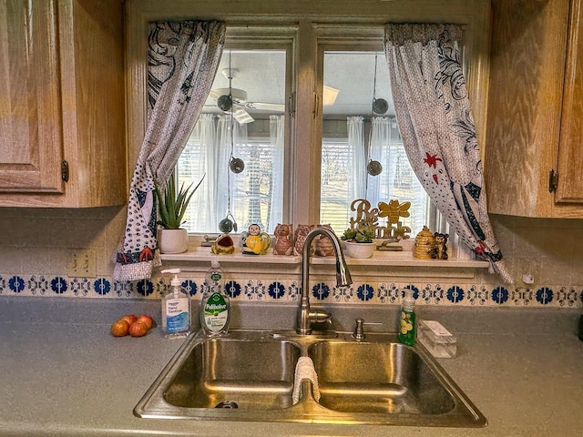 room details with tasteful backsplash, ceiling fan, and sink