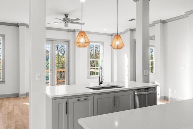 kitchen with a sink, light countertops, ornamental molding, gray cabinets, and dishwasher