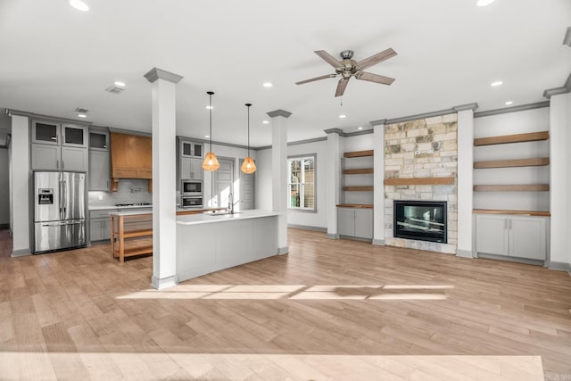 kitchen with light wood-style flooring, light countertops, appliances with stainless steel finishes, gray cabinets, and glass insert cabinets