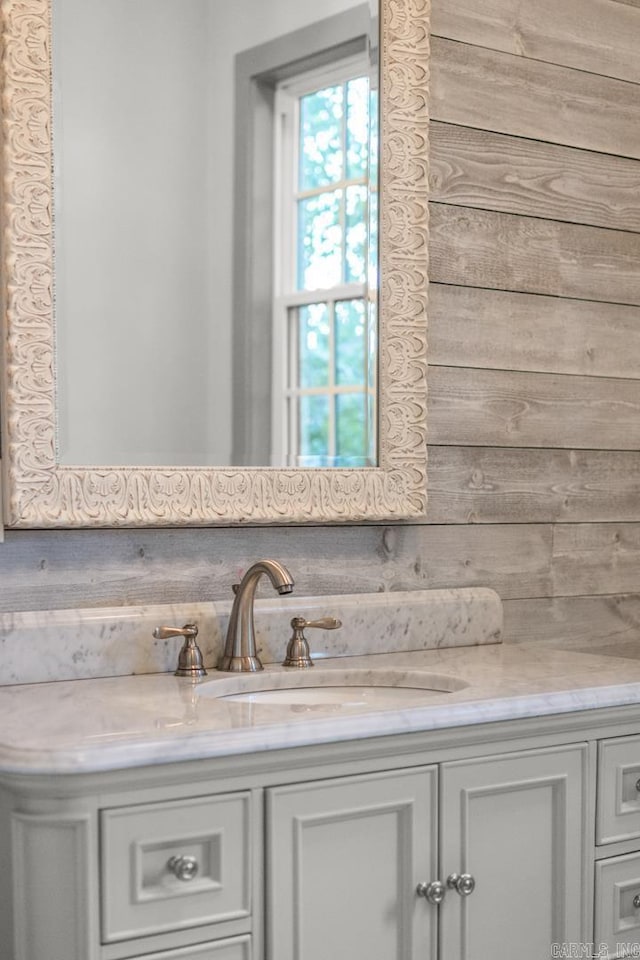 bathroom featuring vanity and wood walls