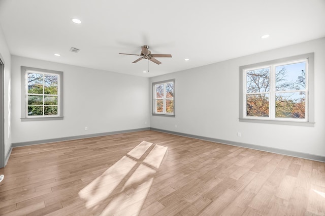 empty room featuring light wood-style floors, plenty of natural light, visible vents, and recessed lighting