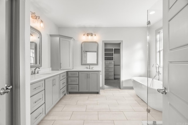 full bathroom with tile patterned floors, a freestanding bath, and vanity