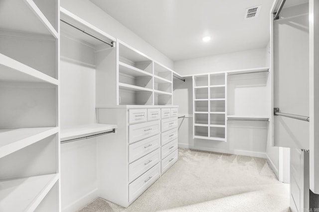 walk in closet with visible vents and light colored carpet