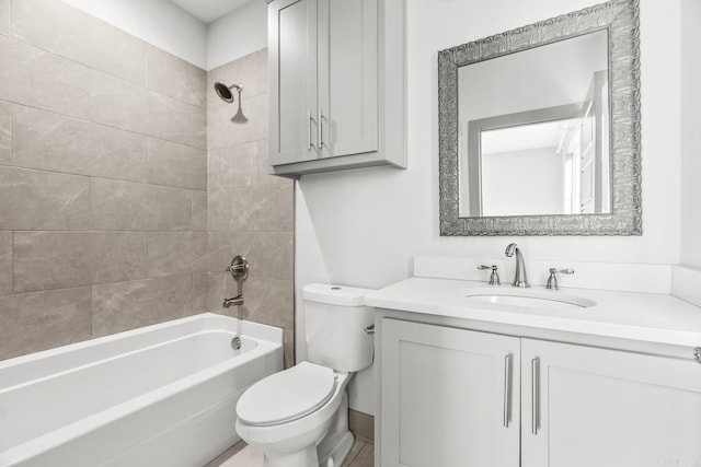 full bathroom featuring tiled shower / bath combo, toilet, and vanity