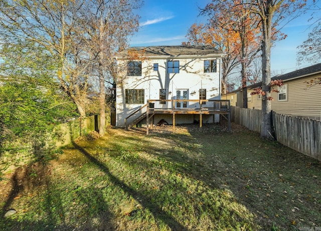 rear view of property featuring a deck, a yard, a fenced backyard, and stairs