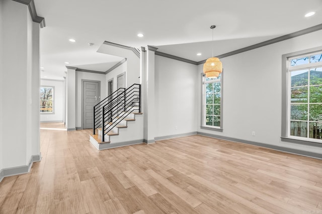 interior space with plenty of natural light, ornamental molding, and light hardwood / wood-style flooring