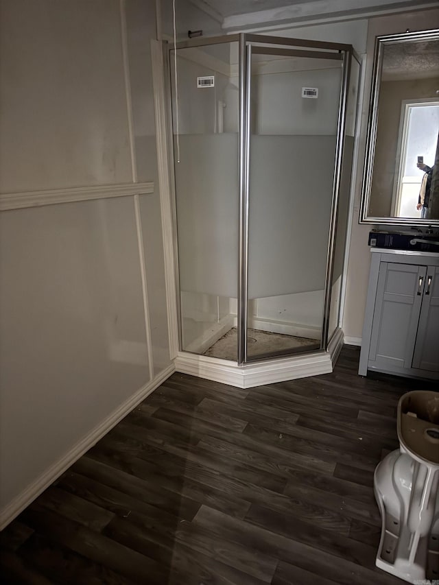 bathroom featuring wood-type flooring, vanity, and walk in shower