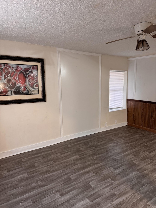 spare room featuring a textured ceiling, ceiling fan, and dark wood-type flooring