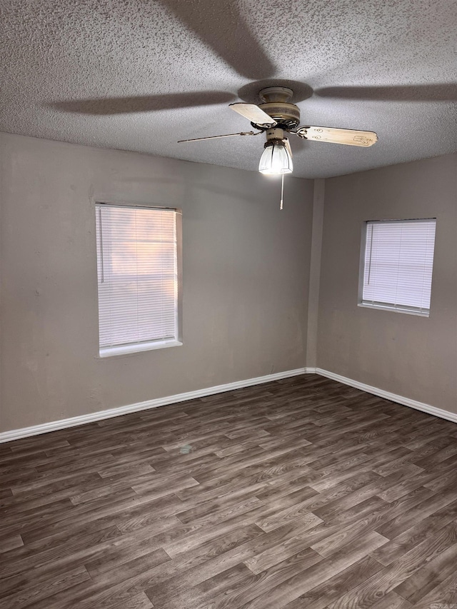 empty room with dark hardwood / wood-style floors, ceiling fan, and a textured ceiling