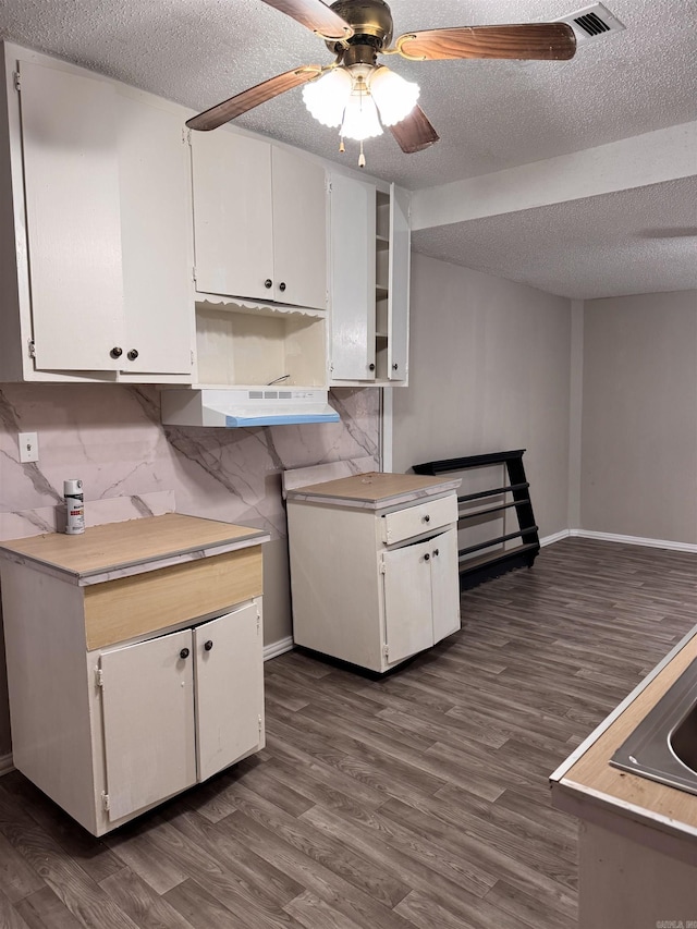 kitchen featuring white cabinetry, dark hardwood / wood-style flooring, and a textured ceiling