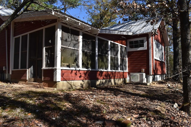 view of side of home with a sunroom and ac unit