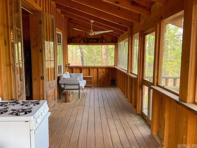 unfurnished sunroom with vaulted ceiling with beams