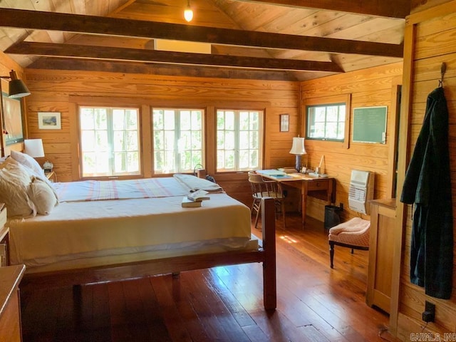 bedroom with multiple windows, wood walls, lofted ceiling with beams, and wood-type flooring