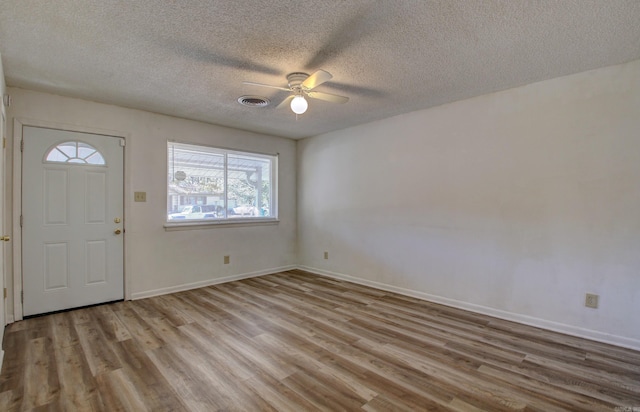 entrance foyer with ceiling fan, a textured ceiling, and light hardwood / wood-style flooring