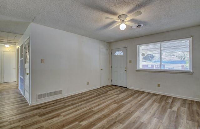 entryway with ceiling fan, light hardwood / wood-style floors, and a textured ceiling