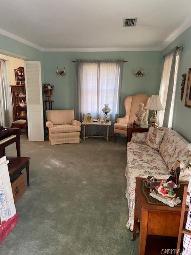 living room with dark colored carpet and ornamental molding