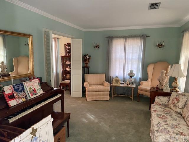 living area with carpet floors and crown molding