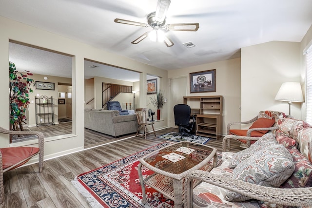 living room featuring hardwood / wood-style floors and ceiling fan