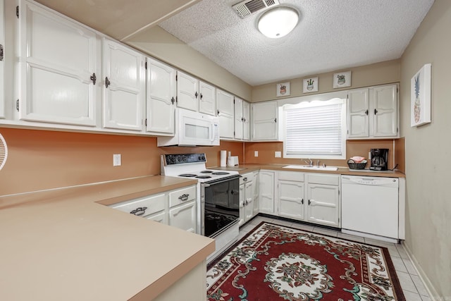 kitchen with white cabinets, white appliances, kitchen peninsula, and sink