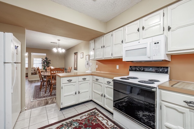 kitchen with kitchen peninsula, white appliances, light hardwood / wood-style floors, white cabinetry, and hanging light fixtures