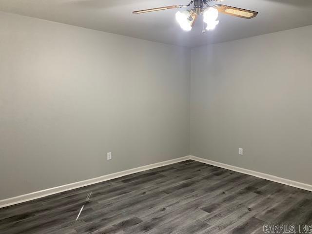 empty room with dark hardwood / wood-style flooring and ceiling fan