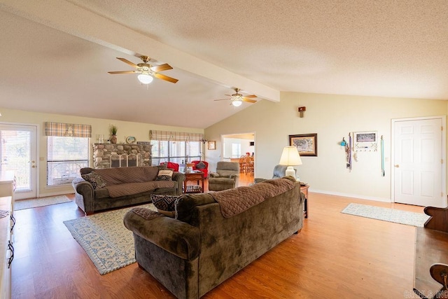 living room with ceiling fan, lofted ceiling with beams, a textured ceiling, and hardwood / wood-style flooring