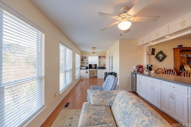 kitchen featuring white cabinets, dishwasher, ceiling fan, and light wood-type flooring