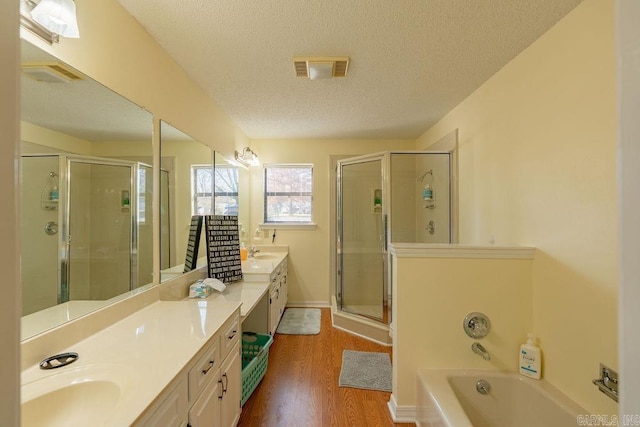 bathroom featuring vanity, hardwood / wood-style floors, a textured ceiling, and independent shower and bath