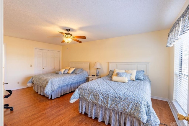 bedroom featuring hardwood / wood-style floors, ceiling fan, a textured ceiling, and a closet