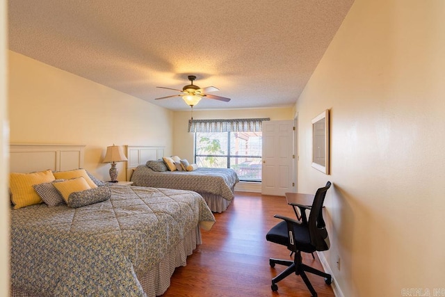 bedroom with ceiling fan, dark wood-type flooring, and a textured ceiling