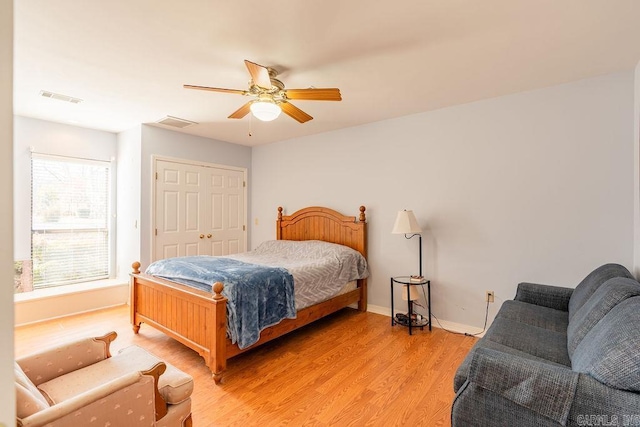 bedroom with ceiling fan, light hardwood / wood-style floors, and a closet