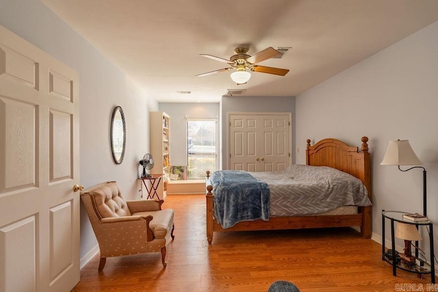 bedroom featuring hardwood / wood-style flooring, ceiling fan, and a closet