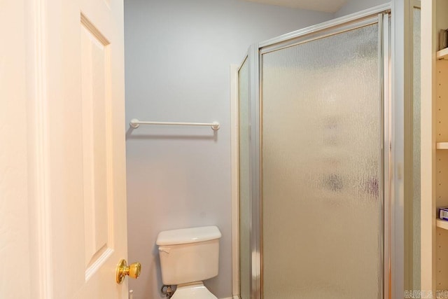 bathroom featuring toilet and an enclosed shower