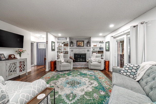 living room featuring a textured ceiling, a fireplace, and dark wood-type flooring