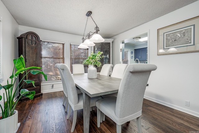 dining room featuring a textured ceiling and dark wood-type flooring