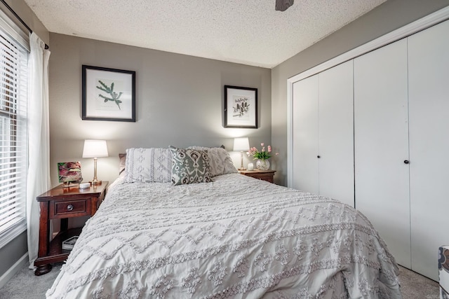 bedroom with a closet, carpet, and a textured ceiling