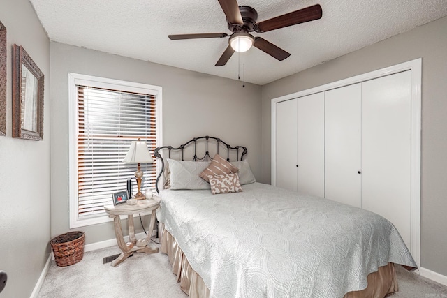 bedroom with ceiling fan, a closet, light colored carpet, and multiple windows