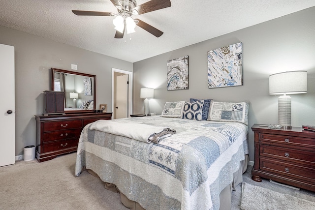 carpeted bedroom with ceiling fan and a textured ceiling