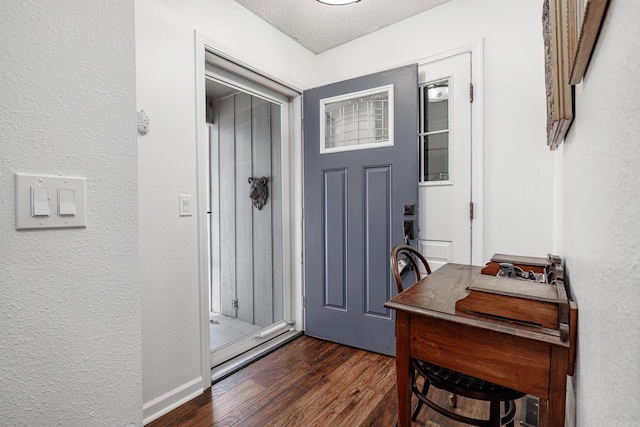 entryway with a textured ceiling and dark hardwood / wood-style floors