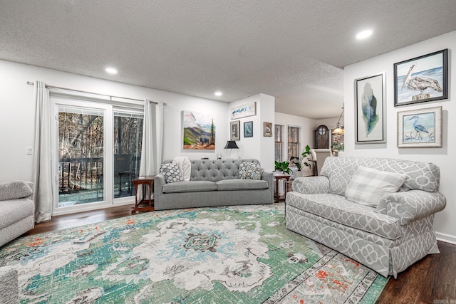 living room featuring a notable chandelier, wood-type flooring, and a textured ceiling