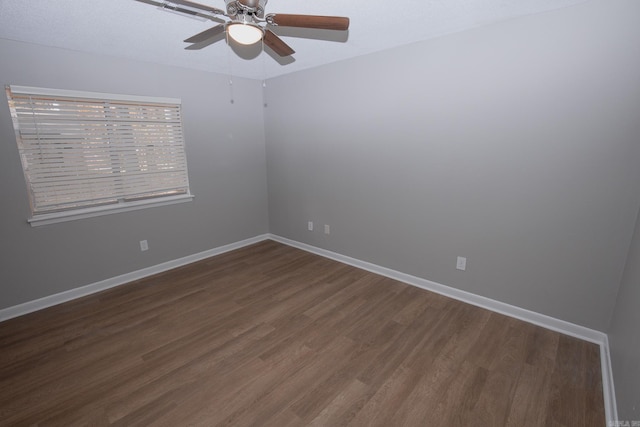 empty room with ceiling fan and dark hardwood / wood-style flooring