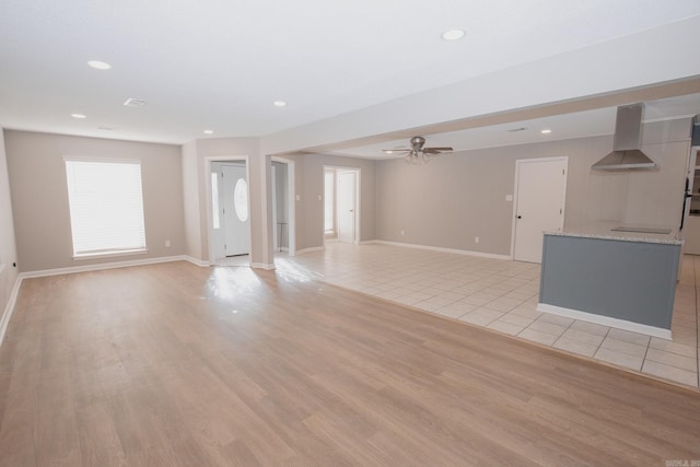 unfurnished living room featuring ceiling fan and light hardwood / wood-style floors