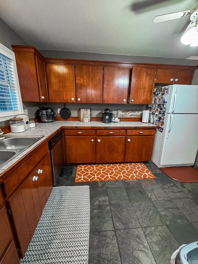 kitchen featuring tasteful backsplash, stainless steel dishwasher, ceiling fan, sink, and white refrigerator