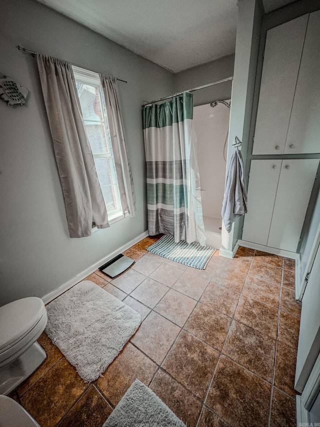 bathroom featuring tile patterned floors, toilet, and walk in shower