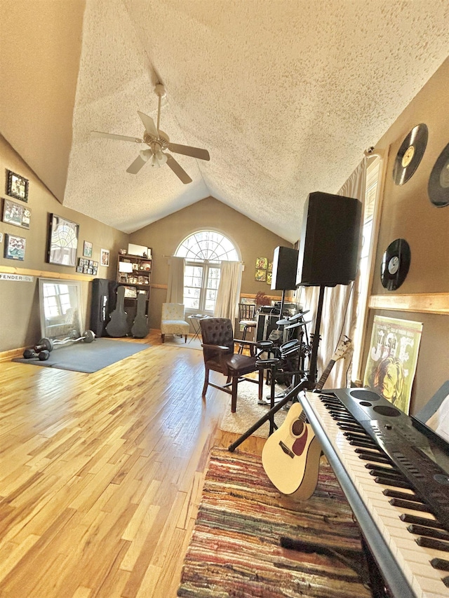 interior space with vaulted ceiling, ceiling fan, a textured ceiling, and hardwood / wood-style flooring