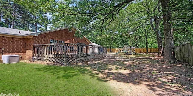 view of yard with a playground, a deck, and central air condition unit