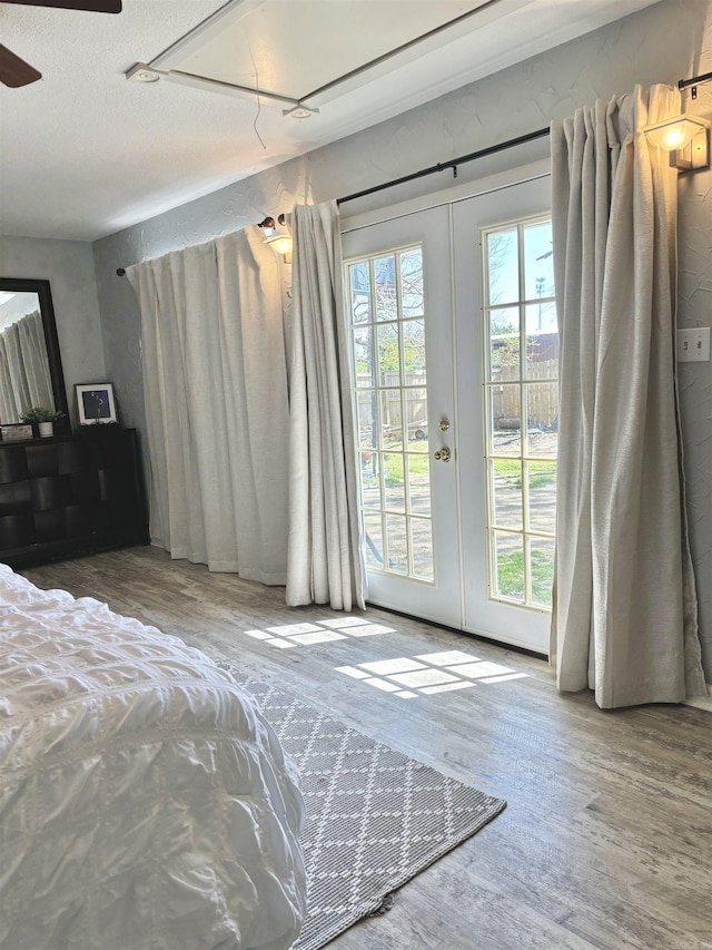 bedroom with access to exterior, multiple windows, and french doors