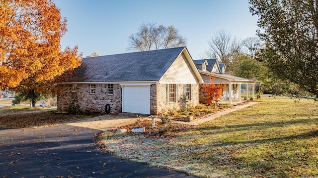 view of side of property featuring a garage and a yard